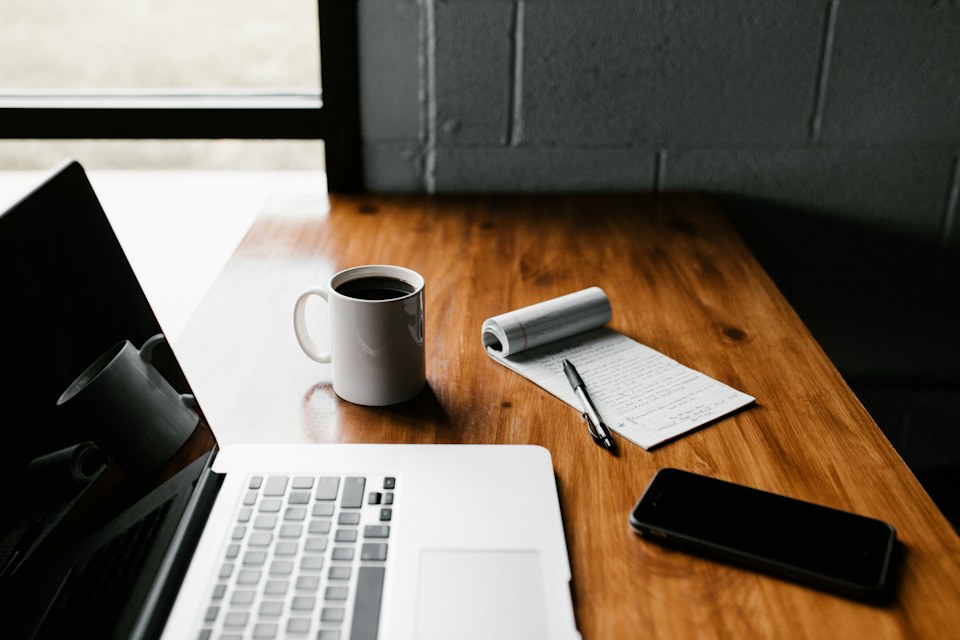 Workspace setup showing newsletter layout preparation on laptop